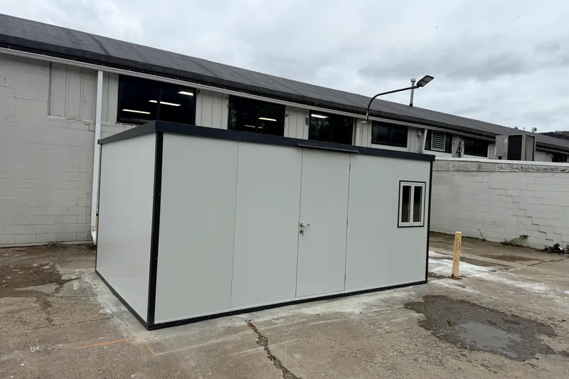 Completed prefab office building with black trim on an industrial lot